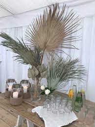Extra Large Dried Tropical Leaves In Clear Glass Vases Make A Very Impressive Beachy Display Perfect For Palm Leaf Decor Leaf Decor Party Cocktail Table Decor