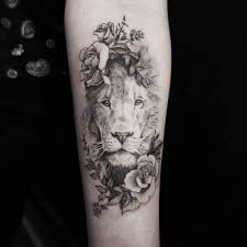Green leaves surround the central tattoo and converge with a simple, red flower at the bottom. 50 Eye Catching Lion Tattoos That Ll Make You Want To Get Inked Kickass Things