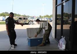 Staff Sgt. Joshua Lewis, a Soldier assigned to 5th Army North, Joint Base  San Antonio, Texas, recieves ice from local police sergeant Steve Angulo  just outside a joint military operations center in