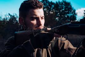 Close Up Snipers Carbine at the Outdoor Hunting. Hunter Aiming Rifle in  Forest. Hunter with Shotgun Gun