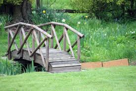 There is a wood bridge there now, (20 years old) 7 sets of 5 2x8x15' boards bolted together w/ cross boards on top connecting them all and runners on top to drive on. Small Bridge Over Creek Backyard Bridges Backyard Small Backyard