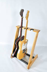 This modern diy wall mount guitar holder is perfect for displaying your guitars without taking up floor space. Handcrafted Wooden Guitar Stand From Allwood By Allwoodstands Diy Guitar Stand Wooden Guitar Stand Guitar Stand