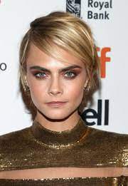 The grown out bangs provide her face with a nice frame while the rest of her hair maintains a smooth finish, with kinky large waves added throughout that fall just past her chin. Cara Delevingne Short Hairstyles Cara Delevingne Hair Stylebistro