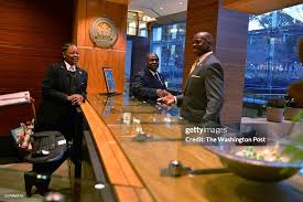 Jean Kabre, R, talks with co-workers Justine Osborne, L, and Daniel... News  Photo