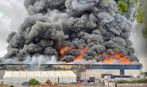 Workers watch as smoke pours from 'warehouse' evacuations are taking. 98e Tetg1hn6gm