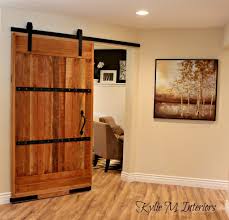 Glass and steel double doors open to a home office featuring light gray desk chairs placed at an oak desk located in front stacked windows. My New Home Office Sliding Barn Door And More