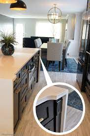 This kitchen island completes its small space with displayed electrical outlets. Black Painted Kitchen Island With Waterfalling Hanstone Quartz Counters And Concealed Outle Painted Kitchen Island Waterfall Island Kitchen Ikea Kitchen Island