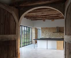 La Cuisine Au Centre De La Grange Sol Beton Cire Mur Pierre Poutres Bois Porte Bois Ancienne Architecte Bordeaux Renovation Grange Architecte