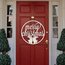 A pair of festive christmas evergreen wreaths adorn a set of large wooden doors, serving as decorations during the holiday beautiful christmas wreath home decorations lights on front door of house. 15 Christmas Door Decorations That You Ll Really Love