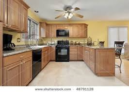 The Light Wood Definitely Makes A Nice Contrast With The Dark Appliances Yellow Kitchen Walls Brown Kitchen Cabinets Paint For Kitchen Walls
