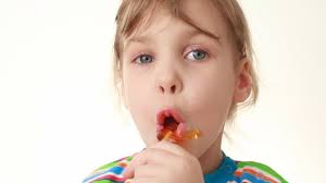 little girl licking lollipop in chicken form
