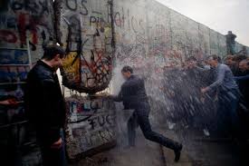 Person sitting on the ground resting back on concrete wall. The Fall Of The Berlin Wall In Photos An Accident Of History That Changed The World The New York Times