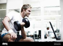 My biceps better bulge when Im done. a handsome young man working out with  a dumbbell in the gym Stock Photo - Alamy