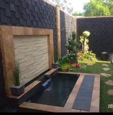 Ditambah dengan panel kayu di sisi kolam, serta lampu downlight pada dinding yang terbuat dari batu alam, membuat kolam dan taman ini tampak sangat kekinian! Jasa Tukang Taman Minimalis Surabaya Dan Gresik Garden Style Jasa Taman