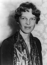 A black and white photo of a woman wearing a scarf. Amelia earhart aviation  pioneer, beauty fashion.