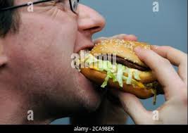 A man eats Big Mac hamburger of McDonald's in Prague, Czech Republic,