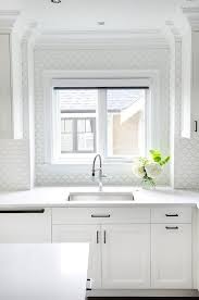 All White Kitchen Features A Stainless Steel Undermount Sink Paired With A Polished N Shaker Style Kitchen Cabinets White Kitchen Faucet Kitchen Cabinet Styles