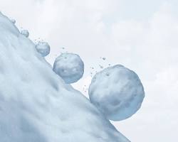 Image of person in shorts and flipflops holding a snowball