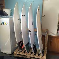 We did not find results for: A Diy Pallet Surfboard Rack Storing 4 White Surfboards Vertically In A Kitchen Next To A Fridge Surfboard Storage Surfboard Rack Surfboard Rack Diy