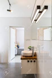 Badsanierung moderne badezimmer mit led beleuchtung from badezimmer beleuchtung , source:qr.schlueter.de. Moderne Hochglanz Weiss Badezimmer Mit Dekorativer Beleuchtung Spiegel Und Arbeitsplatte Mit Waschbecken Offene Turen Im Hintergrund Lizenzfreie Fotos Bilder Und Stock Fotografie Image 70023318