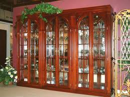Made of cherry with paneled glass doors, interior glass shelves illuminated from above, and lower cabinet. Cherry Curio Cabinet