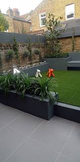 Raised Beds Grey Colour Scheme Agapanthus Olives Artificial Grass Porcelain Grey Tiles Float Small Garden Landscape Modern Garden Design Small Backyard Gardens