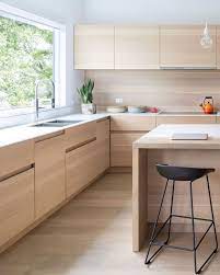 A sleek melbourne kitchen with a simple color palette that makes the space feel light and open, enhanced by the mirrored range hood. A Mid Block Contemporary Home Arrives In Vancouver Interior Design Kitchen Modern Kitchen Design Kitchen Interior