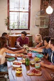 For a treat party, pick glass of wines that are sweeter than the food. Six Friends Making A Toast At A Dinner Party Vertical Stock Photo Picture And Royalty Free Image Image 79574352