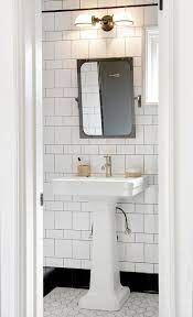 White Pedestal Sink With Aged Brass Rivet Mirror Transitional Bathroom Cottage Bathroom Vintage Bathrooms Industrial Bathroom Lighting