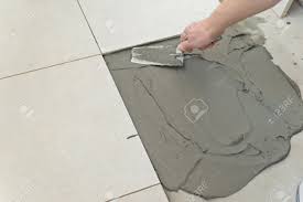 Someone just mentioned to me that it can't be installed over a sealed concrete floor. Laying Ceramic Tiles Troweling Mortar Onto A Concrete Floor In Preparation For Laying White Floor Tile Stock Photo Picture And Royalty Free Image Image 24261227