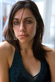 In this photo, PJ Harvey exudes a moody, magnetic presence that perfectly  captures her status as one of rock's most fearless and enigmatic artists.  With her sharp features, dark eyes, and often