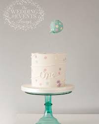 Its topper is a mom in a straw hat pushing a pink baby buggy which holds a smiling baby. First Birthday Cake Modern Simple Cake For Boys Or Girls Baby First Birthday Cake Birthday Cake Girls Girls First Birthday Cake
