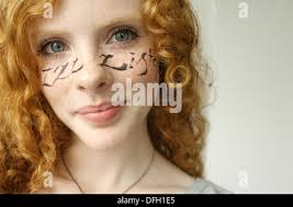 Picture by Matt Gore/ipm Pretty Red head girl with I'll listen written  across her face in Italic Writing Stock Photo
