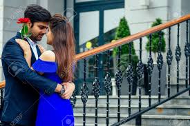 Long Haired Brunette Indian Woman In Blue Dress With Her Handsome Boyfriend  Having Dating .man Giving Rose To His Girlfriend In Summer Downtown Street  Stock Photo, Picture and Royalty Free Image. Image