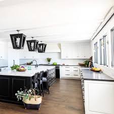 Modern grey shaker style kitchen with white granite worktop. Black And White Kitchen Boasts Three Black Lanterns Above A Black Kitchen Island With A White Marble C Black Kitchen Island Black Kitchens Transitional Kitchen