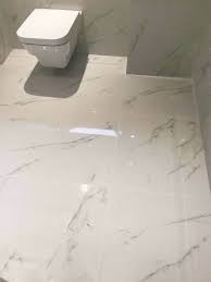 Just the installation of marble stone floors can effortlessly add luxurious opulence and timeless honed finish marble: White Carrara Marble Effect Tile Transform Bathroom Bathroom Flooring Basement Bathroom Design Basement Bathroom Remodeling