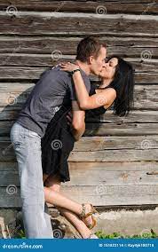 Парень целует девушку на предпосылке дерева Стоковое Фото - изображение  насчитывающей сторона, потеха: 151823114