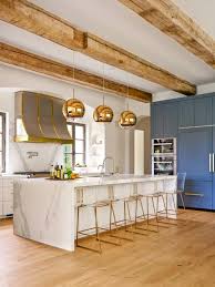 Beautiful light gray kitchen boasts a gold gooseneck faucet mounted to a white countertop over a peninsula sink. Bright Contemporary Kitchen Featuring Long Marble Island And Metallic Gold Accents Hgtv