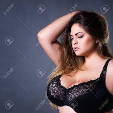 Plus Size Sexy Model In Black Bra, Fat Woman With Big Natural Breast On  Gray Studio Background, Overweight Female Body, Long Hair And Make