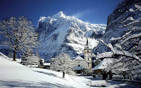 The eiger village of grindelwald in the bernese oberland lies embedded in a welcoming and green hollow, surrounded by a commanding mountainscape with the eiger north face and the wetterhorn. Grindelwald Switzerland Snow Mountains Village Church Winter Hd Wallpaper Peakpx