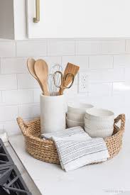 The Perfect Set Up For Next To Your Range A Round Woven Tray Holds Most Used Utensils In A Pretty M Woven Trays White Kitchen Remodeling Kitchen Counter Decor