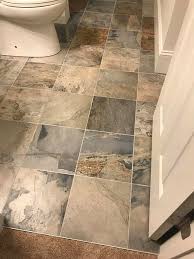 This galley kitchen features soap stone countertops and sink, slate look porcelain tile, and a laundry room hidden in a closet. Florida Tile Legend In Titan Color 12x12 Porcelain Slate Look Tiles With Schluter Profile For Farmhouse Kitchen Decor Floor Transitions Stone Tile Flooring