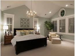 Satin pillows on a minimalist bed by a white empty wall in a trendy bedroom interior with gray and teal green decorations. Light Green Walls Cathedral Ceiling Master Bedroom