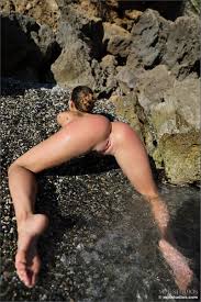 Shaved girl nude by a rocky beach at Brdteengal