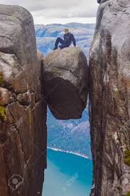 The rock is over 3,280 feet (1,000 meters) high and offers a. The Tourist Hiker Man Sitting On Top Of Kjeragbolten The Most Dangerous Stone In The World