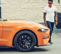 2018 Mustang In New Color Orange Fury Tri Coat Driving Down A Winding Road Next To The Ocean Ford Mustang Mustang Ford