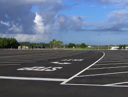 An underground parking complex with no cars and has large white columns with yellow stripes painted on them. Parking Lot Light Control Lantern