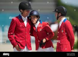USAs Karl Cook, left, Laura Kraut, center, and McLain Ward react after  cpaturing the silver medal in the Equestrian Jumping Team final at the 2024  Summer Olympics, Friday, Aug. 2, 2024, in