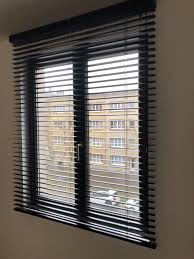 horizontale jaloezie zwart aluminium woonkamer inspiratie lamellen zonwering herentals iando jaloezieen moderne raambekleding gordijnen