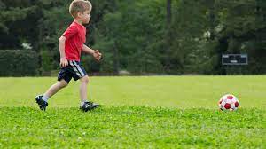 Boys kicking football on the sports field. Introducing Preschoolers To Soccer
